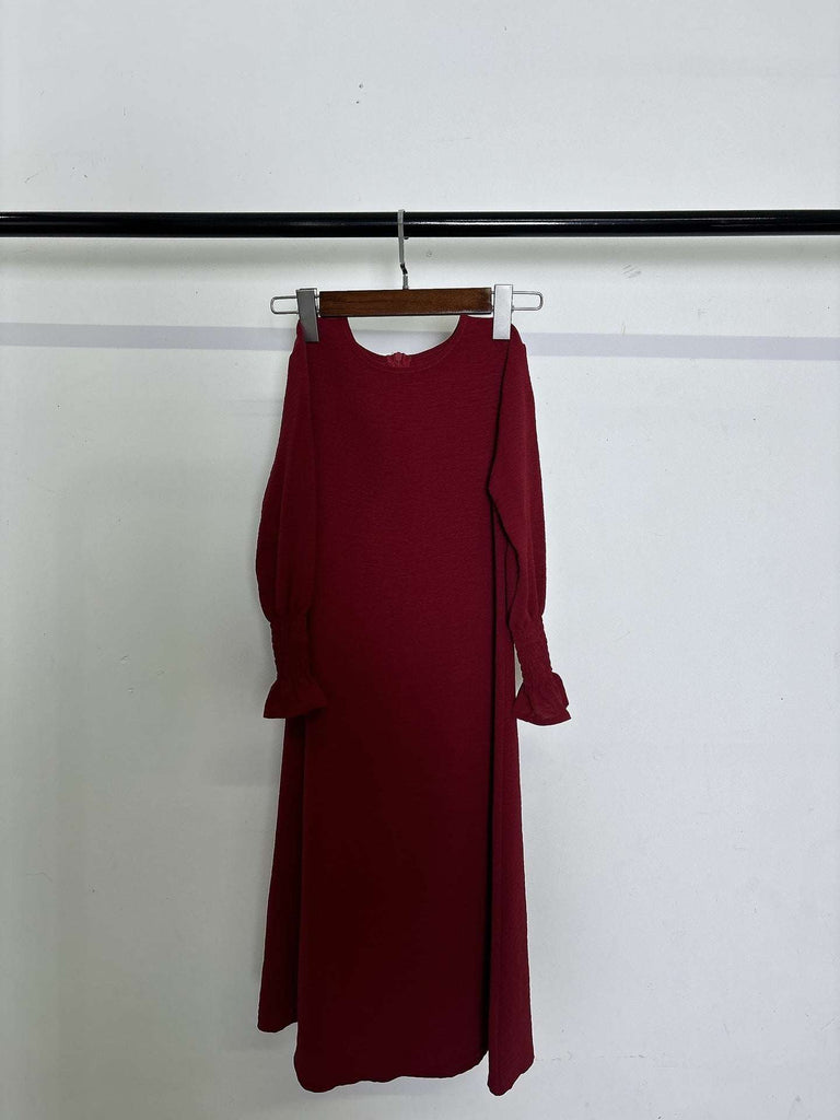 Round neck wavy ruffled long sleeve solid color polyester dress for kids hanging on rack