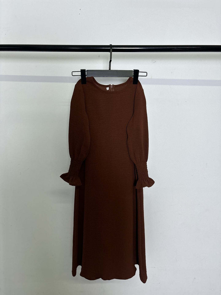 brown round neck long sleeve dress with wavy ruffled cuffs and solid color polyester fabric hanging on black hanger