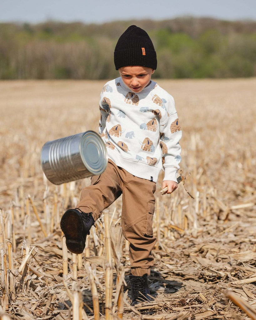 Child wearing taupe twill jogger cargo pants with flap pockets and elastic ankles outdoors