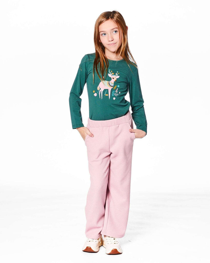 Girl wearing dusty pink waffle flare leg pants with elastic waistband and green long-sleeve top with reindeer print