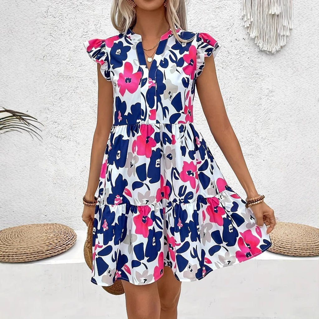 Woman wearing sleeveless women's summer floral print dress with blue and pink flowers on white background