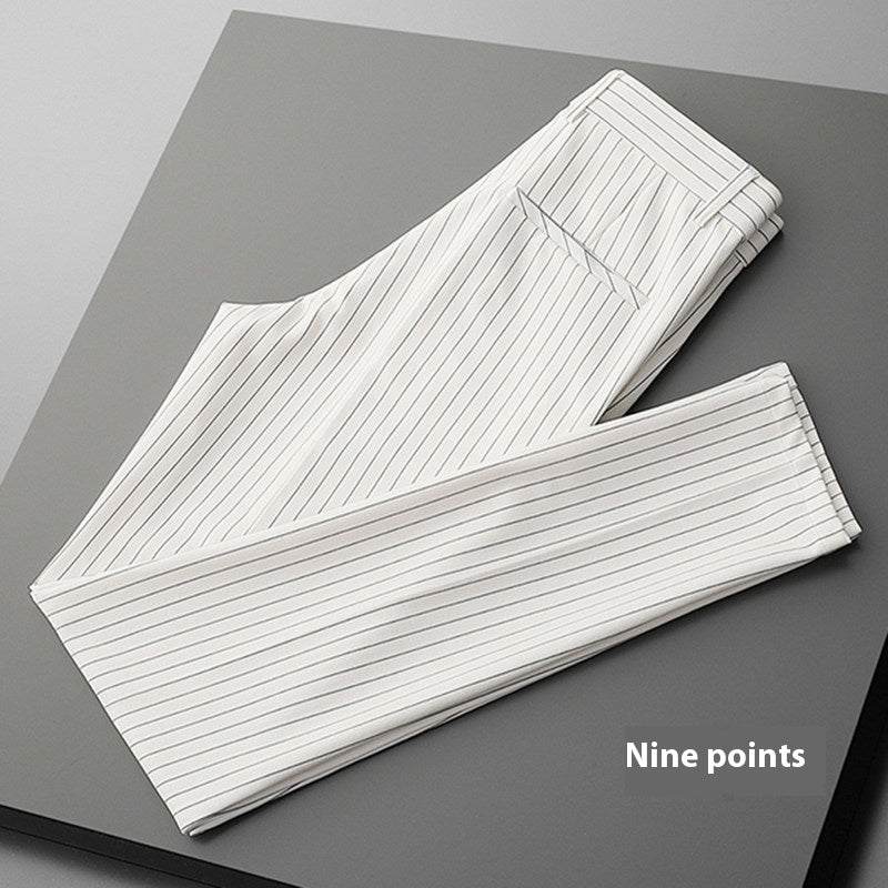 White thin casual striped men's loose draping suit pants folded on gray surface