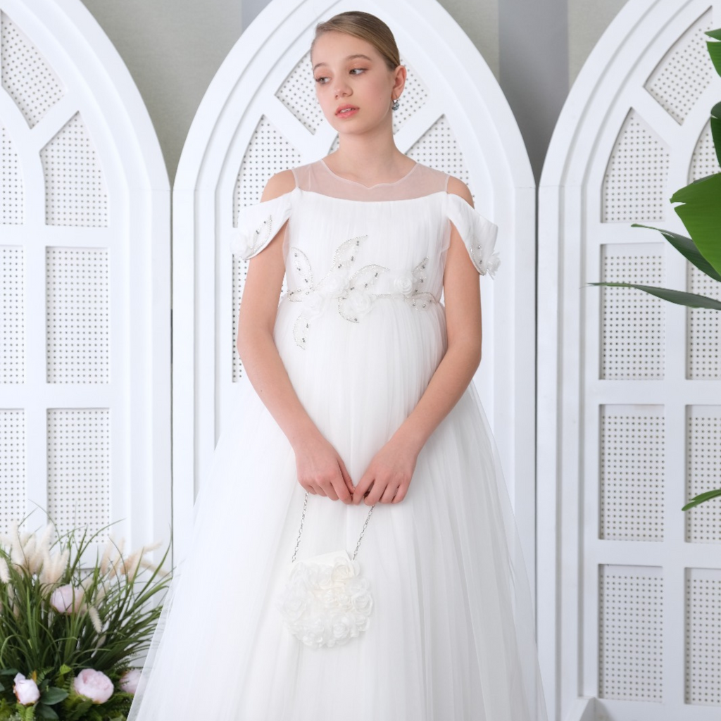 Girl wearing Moonlit Grace Girls Formal Dress with lace bodice, tulle skirt, and floral accents holding a white purse