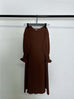 brown round neck long sleeve dress with wavy ruffled cuffs and solid color polyester fabric hanging on black hanger