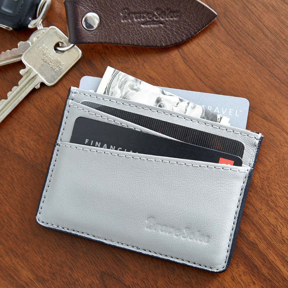 The Voyageur Card Holder made from upcycled leather plane seats with card and cash pockets on wooden surface