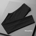 Thin casual striped loose black men's suit pants folded on grey background
