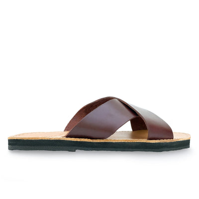 Side view of The Constanza Slide genuine leather slides with crossed brown leather straps and cushioned sole made from upcycled tire material