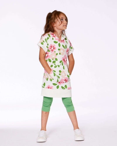 Girl wearing printed French terry hooded dress with pink flowers on white background and green leggings