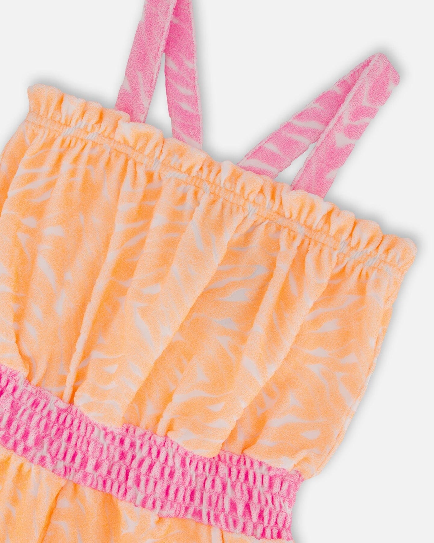 Printed terry cloth romper in vibrant orange and white with pink straps and elastic waistband
