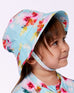 Fille portant un chapeau bleu clair à fleurs assorti à une robe enfant douce à motif floral coloré