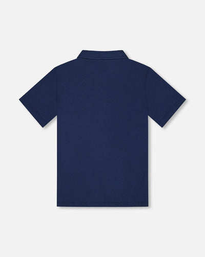 Navy blue short sleeve polo shirt with knit collar and button placket, made from soft stretch cotton fabric.
