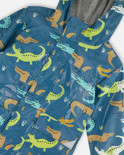 Blue raincoat with color-changing crocodile print, attached hood, reflective accents, and cotton jersey lining