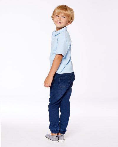 Boy wearing dark denim blue French Terry Denim Jogger pants with elastic ankles and a light blue polo shirt