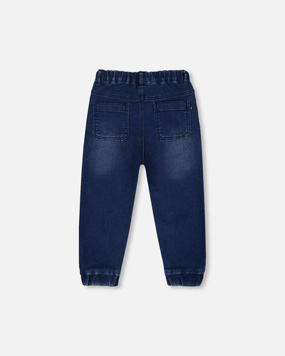 Back view of dark denim blue French Terry Denim Jogger Pant with elastic waistband and ankle cuffs