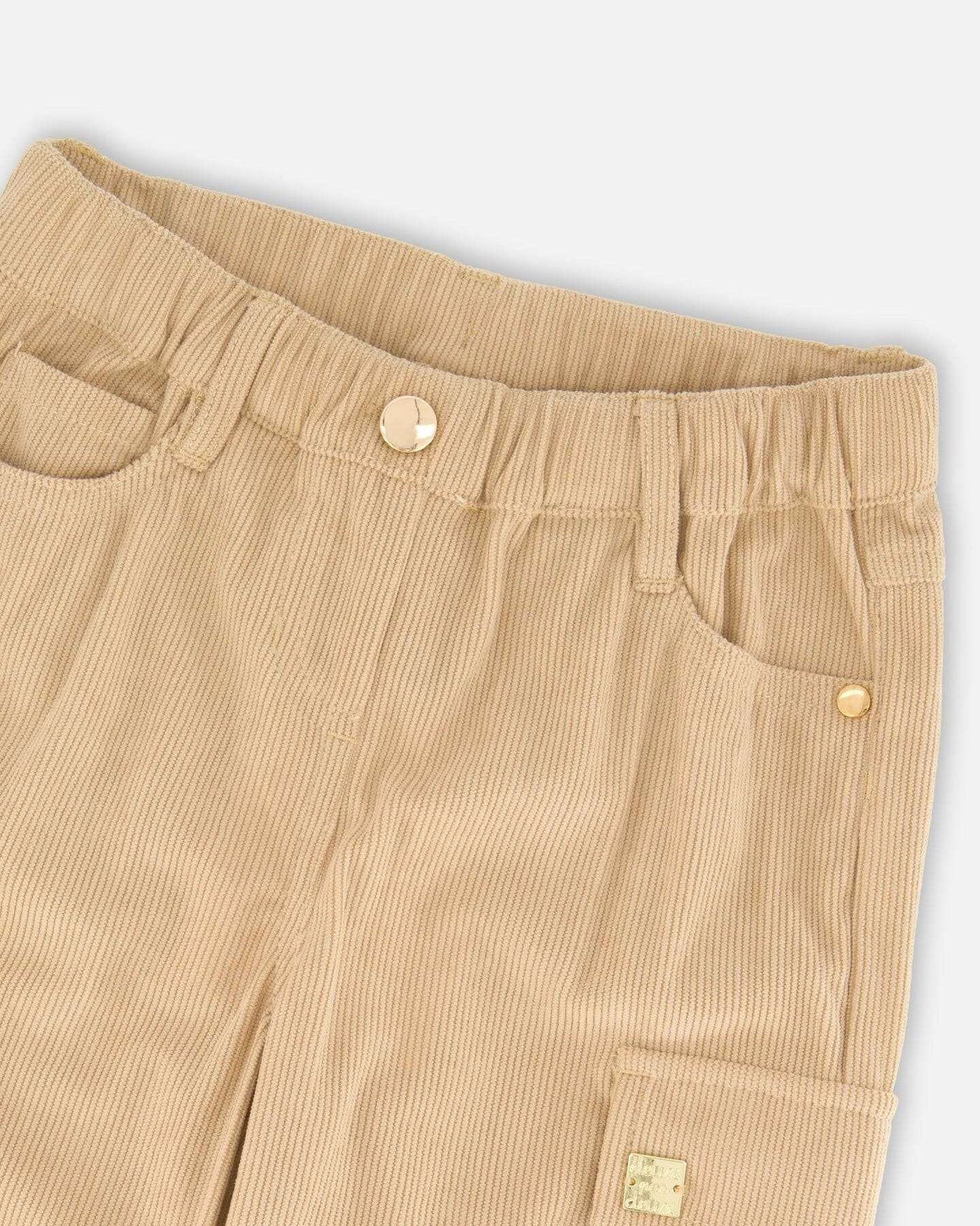 Close-up of light pecan brown parachute corduroy pants with cargo pockets and elastic waistband