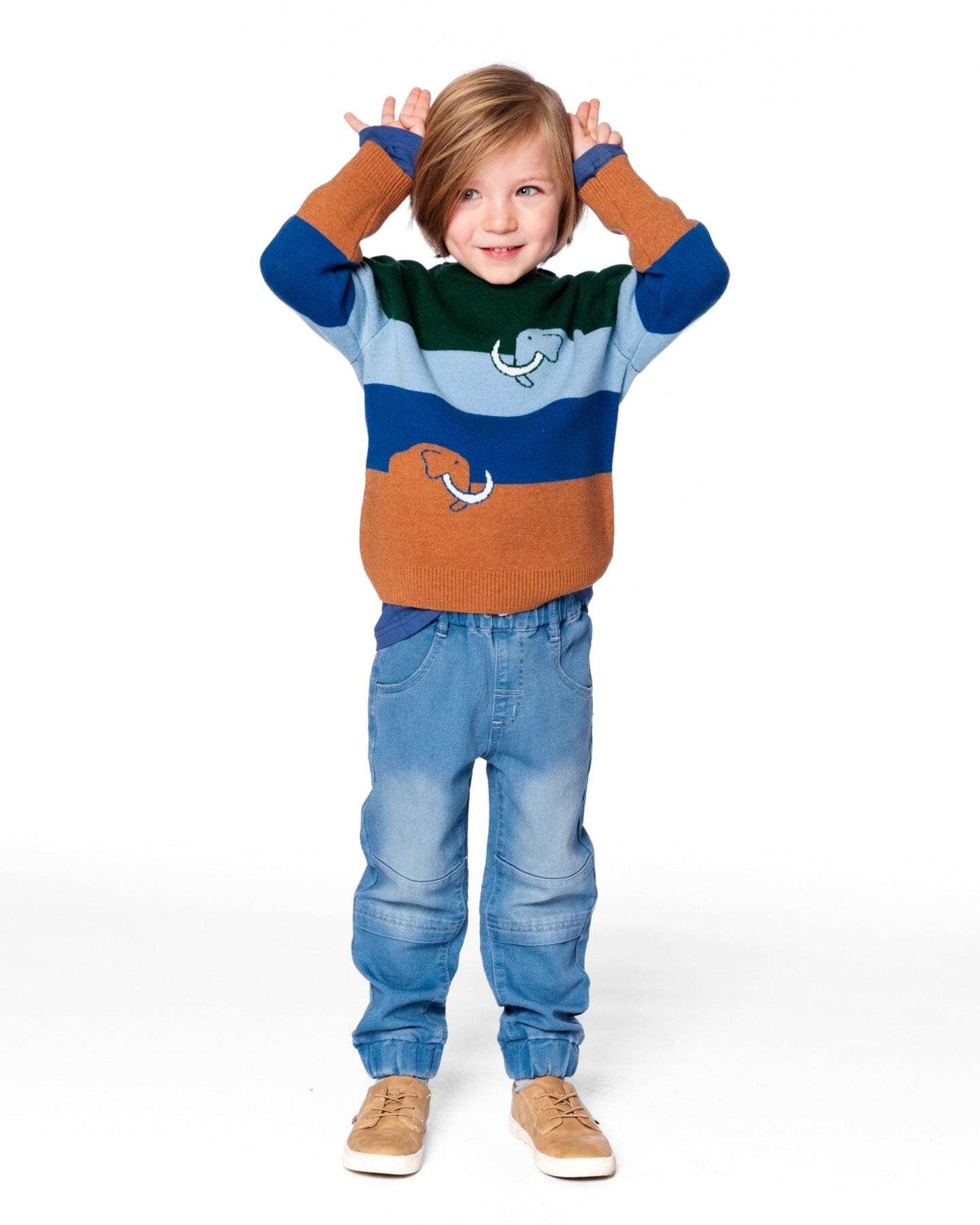 Child wearing light blue denim French terry jogger pants with elastic ankles and seamed knee panels, styled with a colorful sweater and tan shoes.