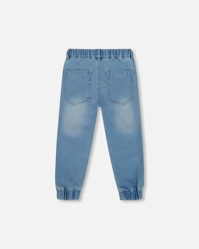 Light blue denim French Terry Jogger Pants with elastic waistband and ankles, featuring back pockets and seamed knee panels.