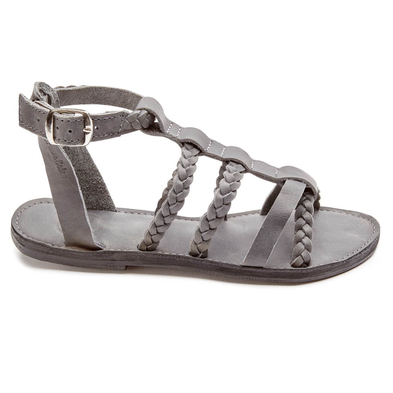 The Kaitlin Gladiator Leather Sandal side view, handcrafted gray leather with braided straps and adjustable ankle buckle, upcycled tire sole.