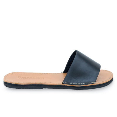 The Linda Leather Slide sandal with black leather upper and natural tan footbed on flat sole