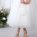 Close-up of Moonlit Grace Girls Formal Dress soft tulle skirt with silver shoes and white floral purse for special occasions