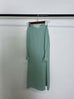 Round neck wavy ruffled solid color long sleeve dress in green polyester fabric hanging on a rack