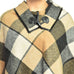 ClaudiaG Plaid Shawl close-up showing beige, black, and white check pattern with toggle closure
