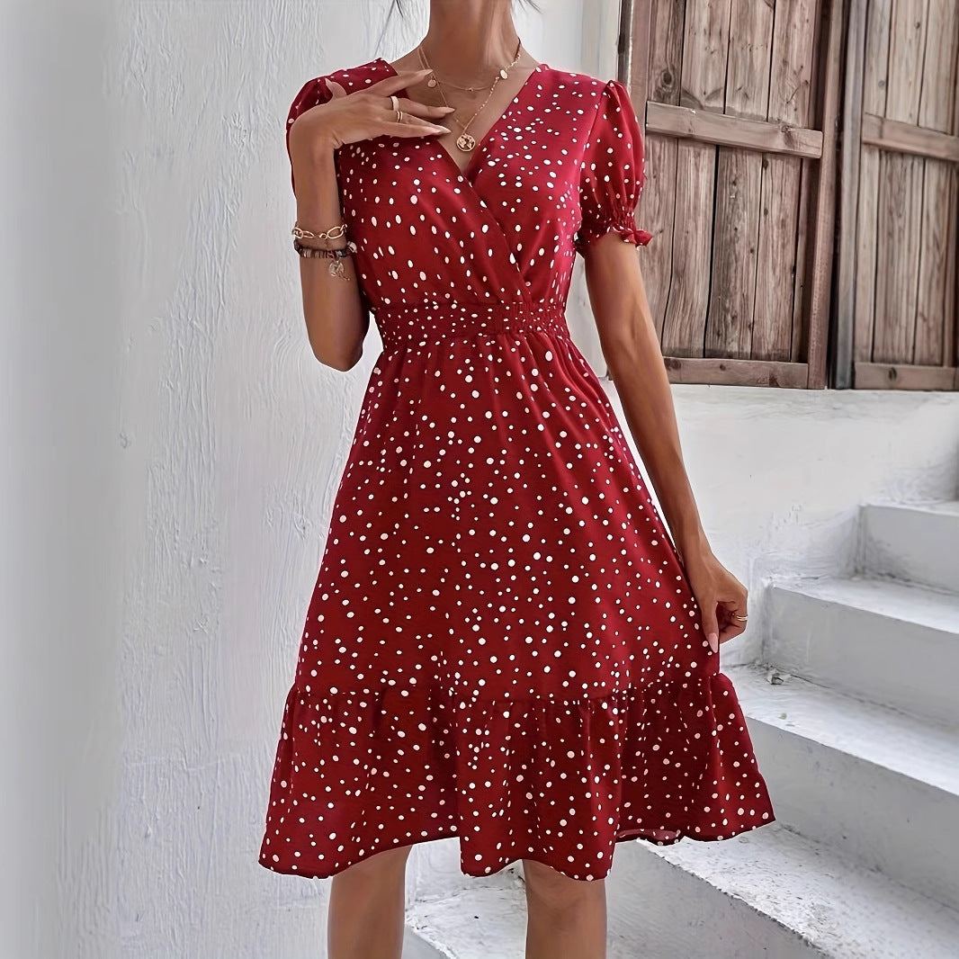 woman wearing casual short sleeve red polka dot A-line dress with cross collar and elastic waist standing by window