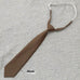 Khaki cotton arrow type men's tie with solid color and adjustable strap on a textured surface