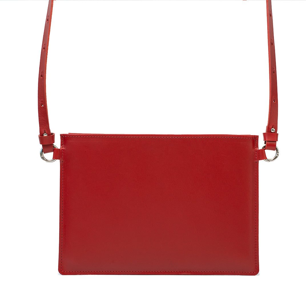 Red slim leather sleeve for iPad with adjustable shoulder strap, handcrafted in Europe, minimalist design.