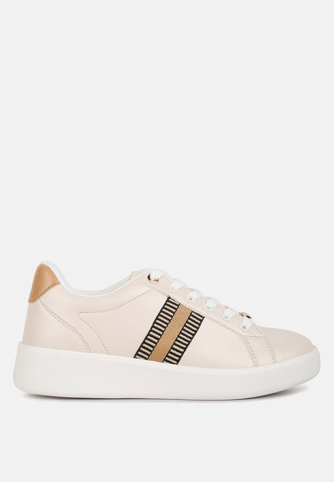 Side view of beige Loyalty Embroidery Detail Sneakers with lace-up closure, embroidery stripes, contrasting back panel, and chunky rubber sole.