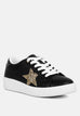 Black chunky sneakers with white laces and glittery gold star detail on side